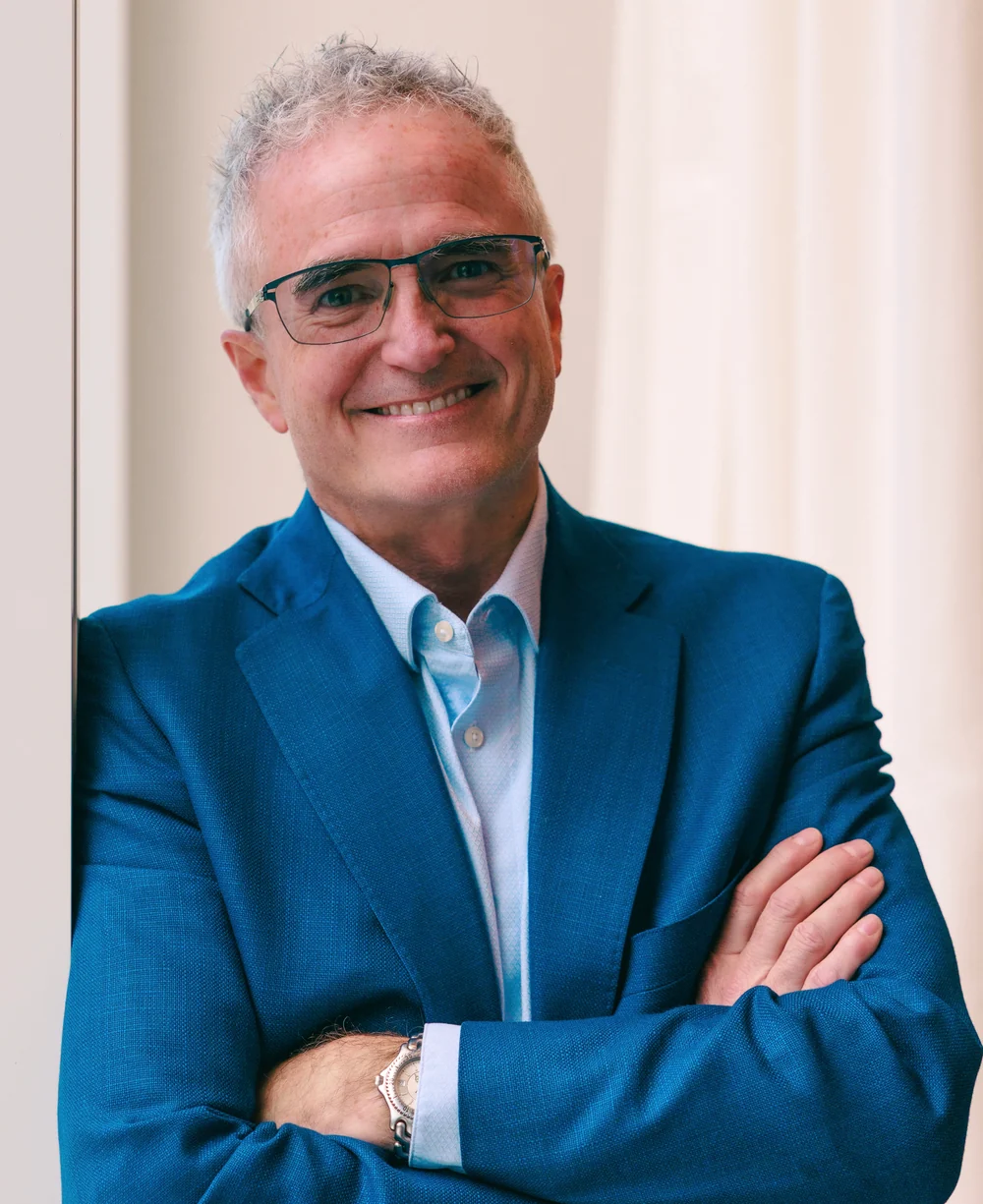 Dr. Jim Arnold, arms folded, in a blue suit