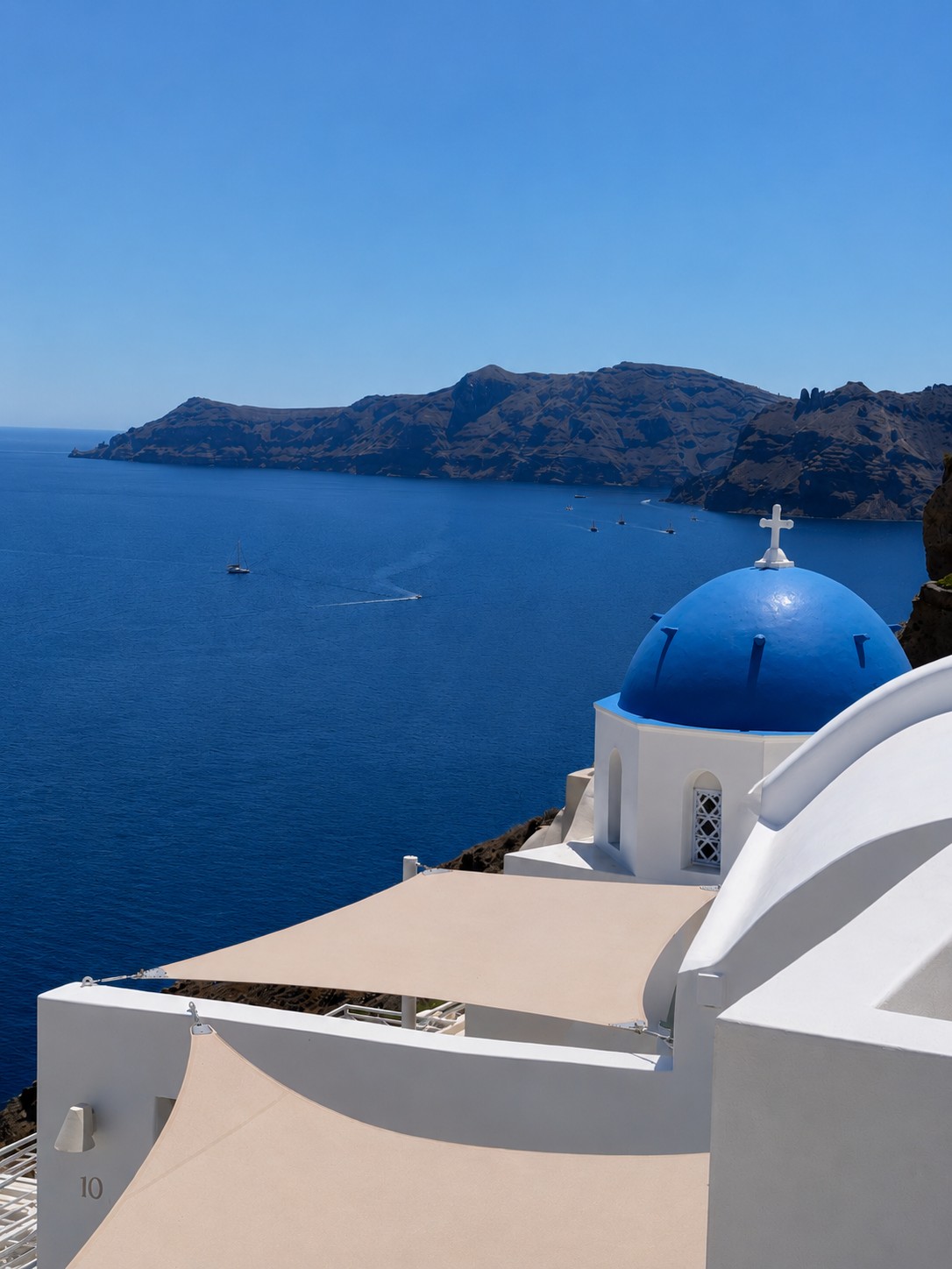 Blue-domed church above the Aegean Sea and the Santorini caldera
